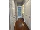 Hallway with storage closets and entry to the bathroom featuring granite countertops at 7601 Newport Bay Dr # 203, Indianapolis, IN 46240