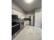 Well-lit kitchen with stainless steel appliances, white cabinetry, granite countertops, and marble floors at 7601 Newport Bay Dr # 203, Indianapolis, IN 46240