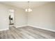 Open-concept space featuring new floors, a modern light fixture, and access to the kitchen at 7650 Micawber Ct, Indianapolis, IN 46256