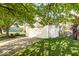 Two-car garage with green lawn, framed by large tree, and easy driveway access at 7650 Micawber Ct, Indianapolis, IN 46256