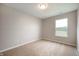 A bright bedroom with neutral walls and carpet features a view through a window at 7918 Wolfgang Pl, Indianapolis, IN 46239