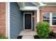 Close-up of the front door with sidelight, brick trim and attractive landscaping at 7918 Wolfgang Pl, Indianapolis, IN 46239