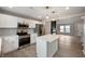 Bright kitchen with island, stainless steel appliances and quartz countertops, seamlessly connecting with the living area at 7918 Wolfgang Pl, Indianapolis, IN 46239