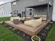Inviting backyard deck featuring a pergola, stylish seating, a modern fire pit, and beautifully landscaped flower beds at 8876 Boylan Pl, Pendleton, IN 46064