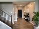 Hallway with staircase, dark door, wood floors, entry table with plant and artwork at 8876 Boylan Pl, Pendleton, IN 46064
