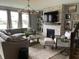 Inviting living room with gray sectional couch, modern fireplace, and a decorative chandelier at 8876 Boylan Pl, Pendleton, IN 46064
