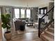 Beautifully decorated living room with gray walls, stone fireplace, and modern chandelier lighting at 8876 Boylan Pl, Pendleton, IN 46064
