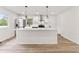 Modern kitchen with white cabinets, stainless steel appliances, a large island, and stylish pendant lighting at 8933 W 1050 S, Fortville, IN 46040