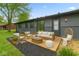 Charming backyard patio with modern outdoor seating, black mulch, and the exterior of the home in view at 8933 W 1050 S, Fortville, IN 46040