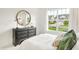 Bedroom with a view to the front of the house from a large window and a gray dresser at 9351 Abner St, McCordsville, IN 46055