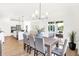 Bright dining area adjacent to kitchen offers a wood table, seating for six, stylish lighting and backyard view at 9351 Abner St, McCordsville, IN 46055