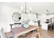 Bright dining area with table, bench, seating for six, stylish chandelier and views of the open concept kitchen at 9351 Abner St, McCordsville, IN 46055