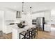 Open concept kitchen with stainless steel appliances, white cabinets, granite countertops, pendant lighting and breakfast bar at 9351 Abner St, McCordsville, IN 46055