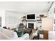 Bright living room with white couches, dark wood coffee table, fireplace, and decorative shelving flanking the television at 9351 Abner St, McCordsville, IN 46055