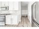 Bright kitchen features white cabinets, stainless steel appliances, and wood-look flooring at 9369 Casey Rd, Pendleton, IN 46064