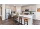 Well-lit kitchen boasts stainless steel appliances, grey cabinets, hardwood floor and center island with bar stool seating at 9387 Abner St, McCordsville, IN 46055