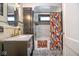Stylish bathroom featuring decorative floral shower curtain and black and white mosaic tile flooring at 949 E Southern Ave, Indianapolis, IN 46203