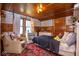 Cozy bedroom with wood-paneled walls, patterned wallpaper, and an inviting chair, creating a charming and comfortable retreat at 949 E Southern Ave, Indianapolis, IN 46203