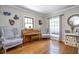Cozy sitting area featuring hardwood floors, classic armchairs, and a vintage piano at 949 E Southern Ave, Indianapolis, IN 46203