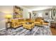 Comfortable living room with a soft yellow sectional sofa, an area rug, and a piano at 949 E Southern Ave, Indianapolis, IN 46203