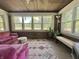 Bright sunroom featuring a cozy pink sofa, decorative rug, and large windows with outdoor views at 949 E Southern Ave, Indianapolis, IN 46203