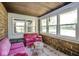 Enclosed sunroom with brick accents, a pink sofa, a patterned rug, and plenty of natural light at 949 E Southern Ave, Indianapolis, IN 46203