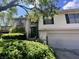 Traditional home with a green front door, trimmed landscaping, and an attached garage at 9560 Bay Vista E Dr, Indianapolis, IN 46250