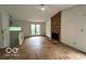 Living room with a brick fireplace, a large window, and stairs at 9560 Bay Vista E Dr, Indianapolis, IN 46250