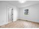 The bedroom has light hardwood flooring, a door to a hallway, and a sunny window overlooking a tree at 9605 W 100 S, Jamestown, IN 46147