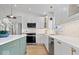 The kitchen boasts modern white cabinets, a green island, quartz countertops, and stainless appliances at 9605 W 100 S, Jamestown, IN 46147