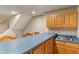 Basement bar with blue countertop, wooden cabinets, and stainless steel sink at 10501 Greenway Dr, Fishers, IN 46037