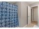 Bathroom with a blue patterned shower curtain, an open door, and tile flooring at 10501 Greenway Dr, Fishers, IN 46037