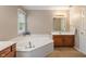 Bright bathroom with a soaking tub, vanity, and ample countertop space at 10501 Greenway Dr, Fishers, IN 46037