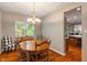 Bright dining room with a chandelier, wood table, and checkered chairs next to the window at 10501 Greenway Dr, Fishers, IN 46037