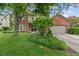 Two-story home with brick accents, lush landscaping, a mature tree, and attached two car garage at 10501 Greenway Dr, Fishers, IN 46037