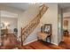 Bright foyer with wood flooring, staircase with wood railing, and a decorative console table at 10501 Greenway Dr, Fishers, IN 46037