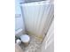 Cozy bathroom features a toilet, gray and white tile flooring, and a decorative shower curtain at 1056 Bent Branch Ln, Greenwood, IN 46143