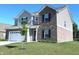 Attractive two-story home boasts a combination of brick and siding with a manicured lawn and young tree at 1056 Bent Branch Ln, Greenwood, IN 46143