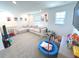 Spacious living room filled with toys and natural light with gray carpet and a large couch at 1056 Bent Branch Ln, Greenwood, IN 46143