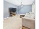 Cozy living room features plush carpeting, a comfortable sofa, and a large screen television for ultimate relaxation at 1117 Oregon Way, Anderson, IN 46012