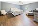 Spacious main bedroom boasting hard wood floors, a ceiling fan, natural lighting, and a comfy seating area at 1117 Oregon Way, Anderson, IN 46012