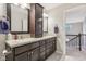 Double vanity bathroom featuring a large cabinet, granite countertop, and framed mirrors at 11844 Pine Meadow Cir, Fishers, IN 46037
