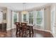 Bright dining room with wood floors, elegant lighting, and large windows offering backyard views at 11844 Pine Meadow Cir, Fishers, IN 46037