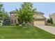 Two-story brick and siding home boasts an attached garage, lush lawn, and mature trees at 11844 Pine Meadow Cir, Fishers, IN 46037