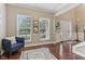 Bright and open foyer with hardwood floors, and a blue accent chair in adjacent sitting room at 11844 Pine Meadow Cir, Fishers, IN 46037