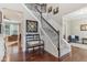 Bright foyer featuring hardwood floors, staircase, a decorative mirror, and a bench seat at 11844 Pine Meadow Cir, Fishers, IN 46037