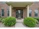 Charming brick home entrance with decorative shrubs, stone detail and glass paneled front door at 11844 Pine Meadow Cir, Fishers, IN 46037
