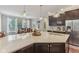Well-lit kitchen with a large island, granite counters, wood cabinets, and a view of the dining area at 11844 Pine Meadow Cir, Fishers, IN 46037