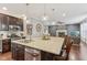 Open kitchen with granite island, stainless steel appliances, dark cabinets, and a seamless flow to the living room at 11844 Pine Meadow Cir, Fishers, IN 46037