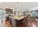 Spacious kitchen island with stone countertops, stainless appliances, and dark cabinets open to living room at 11844 Pine Meadow Cir, Fishers, IN 46037